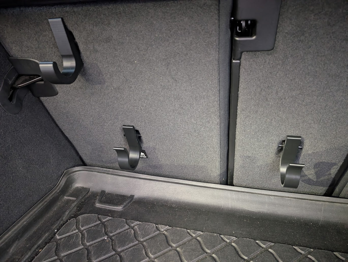 Indkøbskrog klikket fast på ISOFIX-beslaget på bagsiden af bagsædet i bagagerummet